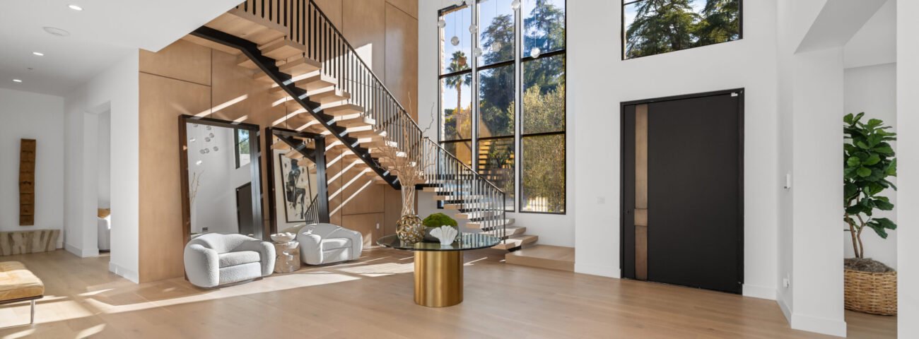 Spacious, elegant living room featuring stunning wooden floors and staircase